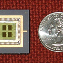 The glass microchip on the left measures 3 centimeters across—slightly more than the diameter of a quarter on the right—and is divided into four nanosoccer playing fields.