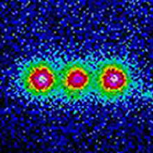 This colorized image shows the fluorescence from three trapped beryllium ions illuminated with an ultraviolet laser beam. 
