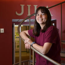 Deborah Jin standing on the staircase at JILA