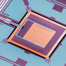 Colorized micrograph of a NIST chip combining four micro-refrigerators with a superconducting sensor