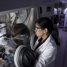 NIST researcher Leah Lucas examines thin film transistors made on plastic rather than silicon using a protective glove box.