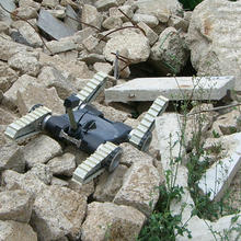 An urban search and rescue robot moves across a rubble pile