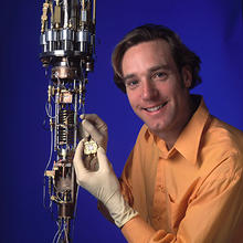 NIST physicist Ray Simmonds holds a protective box containing "artificial atoms" that might be used in quantum computers.