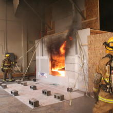 Firefighters outside a NIST test facility for examining  the impact of wind on fire spread