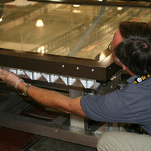 NIST technician putting bolts into the map encasement