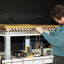 A side view of the DOI encasements with a NIST engineer working on them.