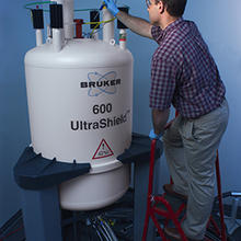 NIST research chemist John Marino places a RNA sample into the magnet of a nuclear magnetic resonance instrument