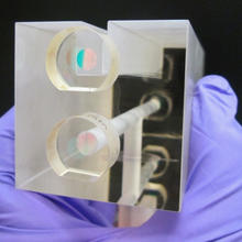 A NIST researcher holds a fixed length optical cavity (FLOC), a structure that enables highly accurate, quantum-based measurements of  pressure.