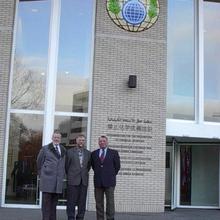 Three NIST scientists standing in front of the OCPW building