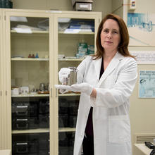 Elizabeth Gentry holding a kilogram test weight in the weights and measures training lab