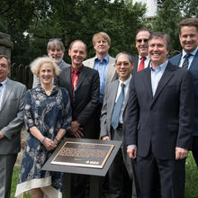 Various NIST employees with the posing with plaque commemorating the invention of the atomic clock on the campus of what is now the University of the District of Columbia