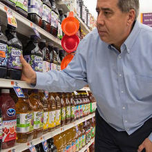 Man selecting grape juice in grocery store