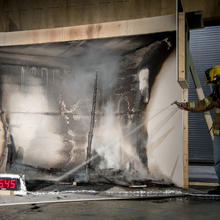 NIST employee spraying water to put out a fire