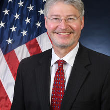 Headshot of Walter Copan with an American flag as the background