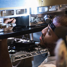 Asia Robertson of NIST’s Fabrication Technology Office makes final adjustments on an encasement.