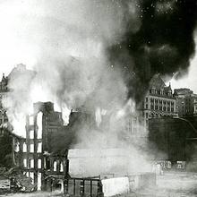 Black and white photo of office buildings burning in 1928.