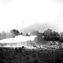 Black and white photograph of a underground shelters on fire. 