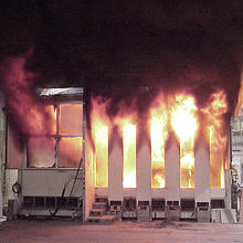 Color photo of white structure meant to replicate and office on fire. 