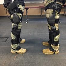 The legs of two soldiers with exoskeletons