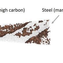 Laser-assisted atom probe tomography of weld region showing high-carbon interlath material with an isoconcentration surface of nominally 0.8 at. % embedded in martensite steel.  Image shows a tip from two viewpoints that is mostly interlath material.