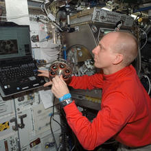 Astronaut aboard the International Space Station is seen preparing a carousel holding samples of materials for a smoke detection test.