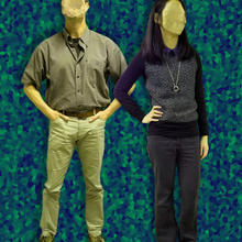 Man and woman with faces scrubbed out against an abstract backdrop.