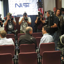 Dave Wineland (left) and Eric Cornell (right) sitting in chairs while photographers take their picture