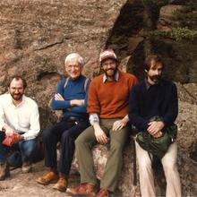 Four men sitting on a rock