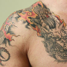 man's shoulder with a dragon tattoo