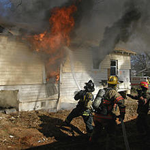 House burning. Firefighters are using a host to douse the flames.