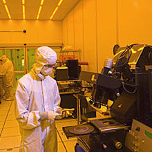 Man in a clean suit stands in front of a chip oven