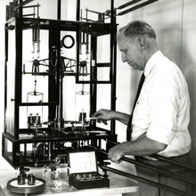 researcher loading weights onto a balance scale