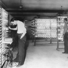 two researchers examining instruments in a laboratory filled with illuminated lightbulbs