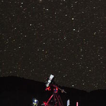 An instrument on a red scaffold stands in front of a starry night sky.