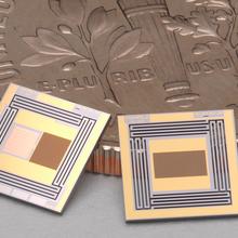 Two tiny square chips are shown with a coin for scale. 