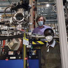 Two men standing amid high tech metallic instruments.