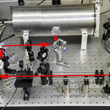 illustration showing the path of laser light before it enters the optical cavity inside the metal cylinder