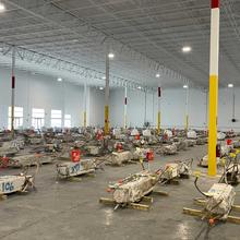 Concrete columns lay on their sides inside a warehouse with lots of space around each one.