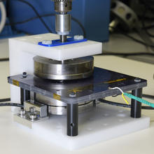 Scientific device includes circular magnets mounted on a black platform wired to other components.