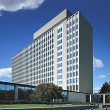 Narrow 11-story building rises into a blue sky.