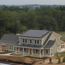 A newly built two-story home has solar panels on the roof.