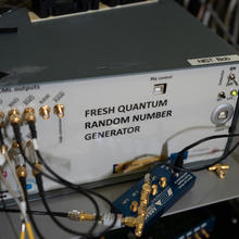 Box-shaped device with wires and connectors is labeled: Fresh Quantum Random Number Generator.