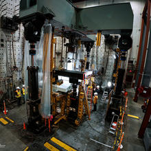 High-ceilinged lab space holds large pieces of equipment surrounding concrete slabs.  