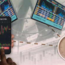 Illustration shows analog clock with images from a trading floor and a hand holding a smartphone showing stock values with buy/sell buttons.