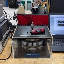 Electronic devices are stacked on a desktop, along with a laptop computer. One device is labeled ENTR_v2.