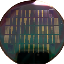 Shiny, dark circular surface has rows of microchips embedded on it. 
