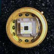 Square chip is fixed to a round metal surface. 