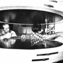 two men working on a 1000-mm guarded hot plate. black & white.