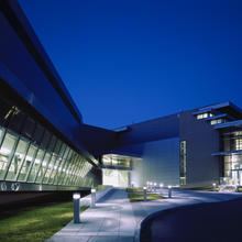 night view of AML building. Dark blue sky. Lights on inside the building.