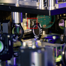  A close-up photo of the center of the experimental set-up. The small transparent chamber that holds the ultracold rubidium atoms is surrounded by a dotted line.